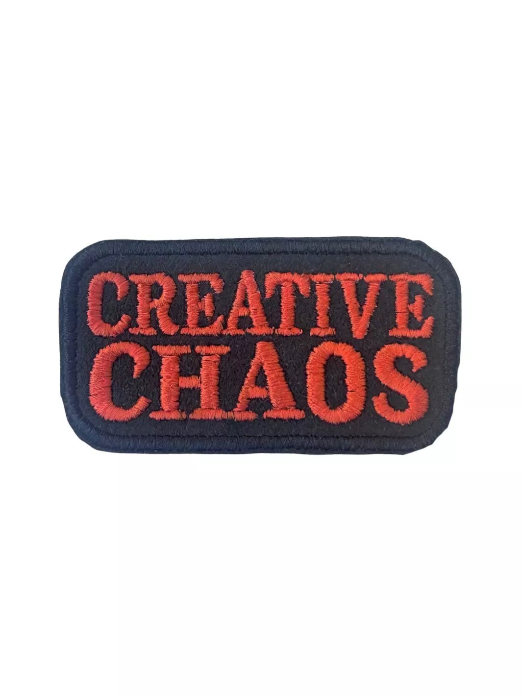 Creative Chaos embroidered iron-on patch with coral-red lettering on a black background