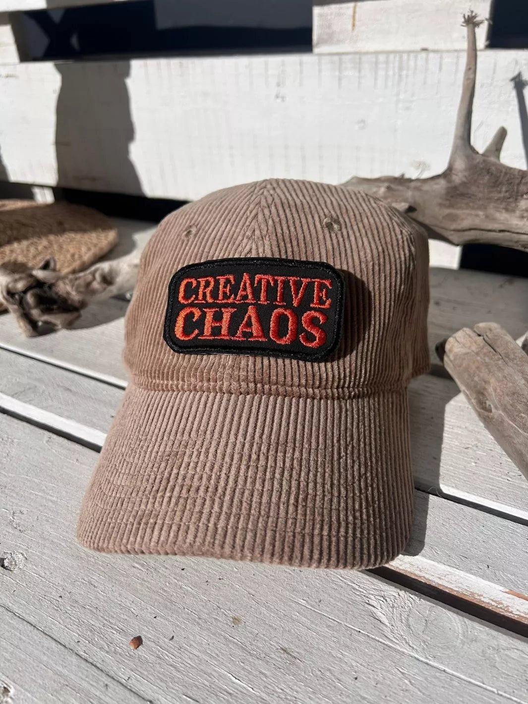 Creative Chaos embroidered iron-on patch with coral-red lettering on a black background