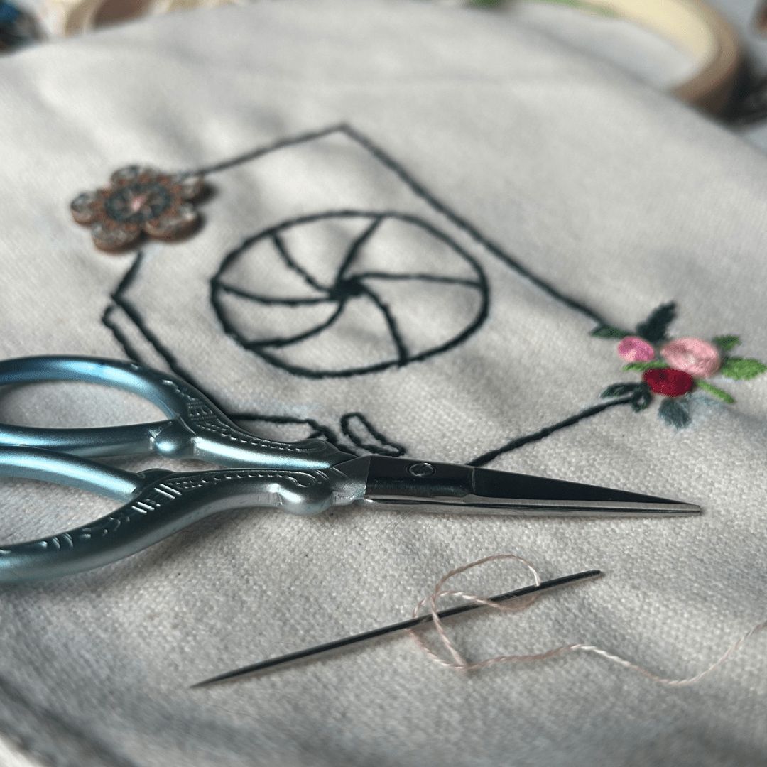 hand embroidered cotton clutch bag with needle and scissors on the side