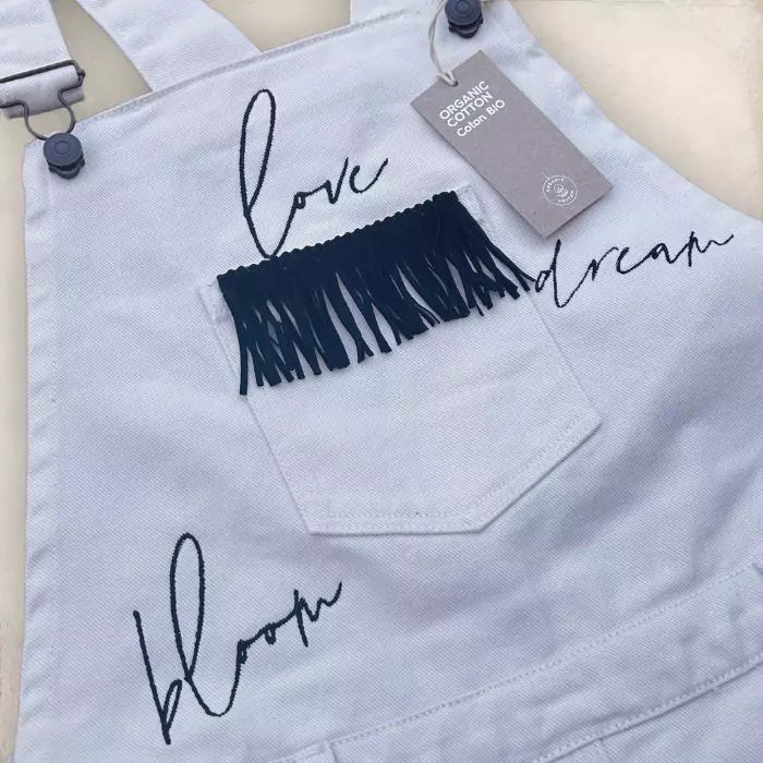 white skirt dungarees in organic cotton with embroidery and stitched fringes