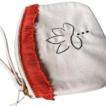 organic cotton clutch bag with a hand-embroidered lotus flower and an orange fringe sewn on top