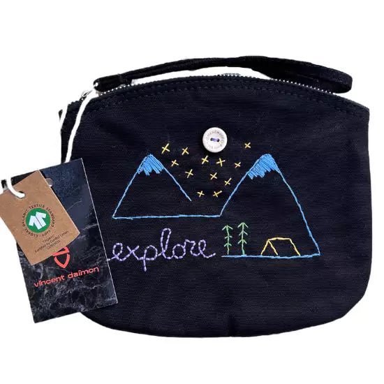black organic cotton clutch bag embroidered with the word explore with snowy mountains,trees and a tent