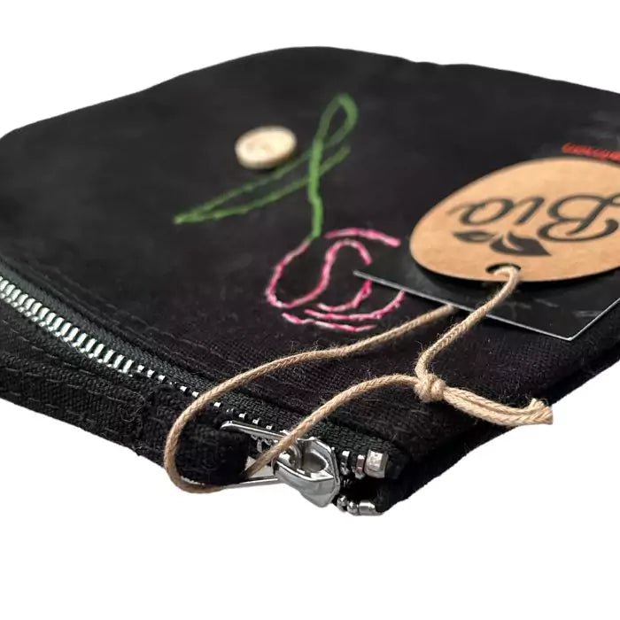 black organic cotton clutch bag embroidered with a tulip adorned with a button bearing the words "handmade with love"