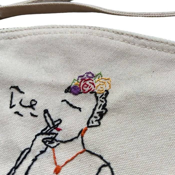 White clutch bag in organic cotton with hand-embroidered Frida Kahlo smoking