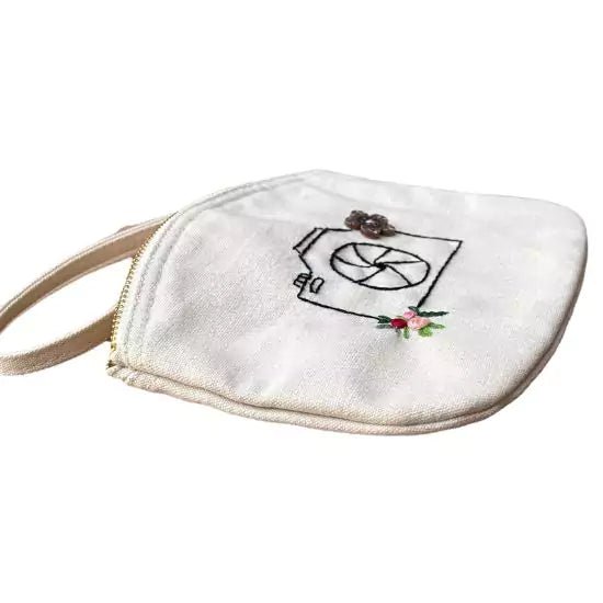 organic cotton clutch bag with a camera and flowers embroidered on it