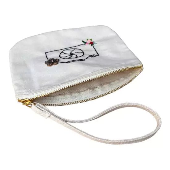 organic cotton clutch bag with a camera and flowers embroidered on it