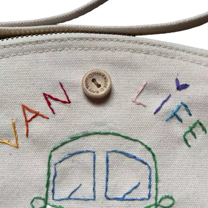 white clutch bag in organic cotton with a camper and the words "van life" embroidered on it