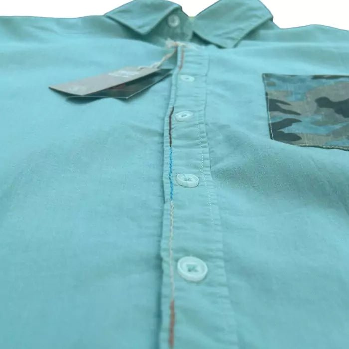 sage-colored organic cotton shirt with sewn military pocket and "explore" embroidered writing in the buttonhole