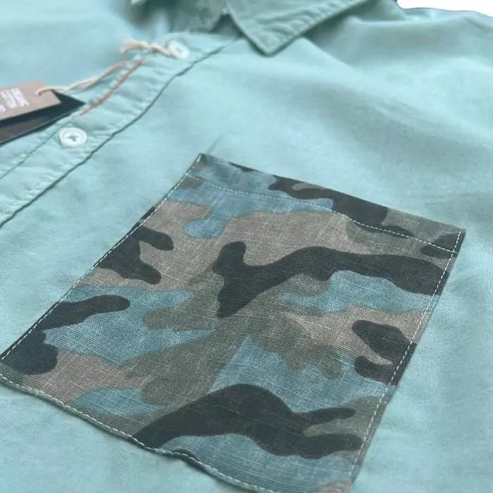 sage-colored organic cotton shirt with sewn military pocket and "explore" embroidered writing in the buttonhole