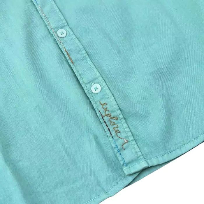 sage-colored organic cotton shirt with sewn military pocket and "explore" embroidered writing in the buttonhole
