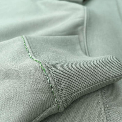 Eco-sustainable almond green sweatshirt with embroidery along the seams of the collar and right wrist